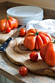 frische Tomaten auf Holzbrett, Messer