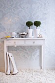 Weisser Konsolentisch auf Hochflorteppich vor Mosaikwand in Weiß & Silber