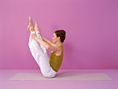 Pilates - Open Leg Rocker: sitzt Beine oben, Hände an Knöchel, Step 1