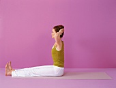 Pilates - Neck Pull: Frau sitzt, Beine u. Rücken gerade, Step 4