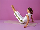 Pilates - Hip Twist: Frau sitzt Beine heben, Step 1