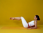 Pilates - Hip Twist: Frau auf Arme gestützt, Beine gebeugt heben