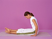 Pilates - Boomerang: Frau sitzt, Beine gestreckt übereinander, Step 1
