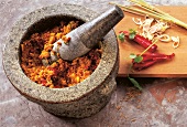 Paste of herb and spices in mortar with pestle