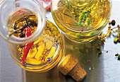 Herbs and spices with oil in glass jars, overhead view