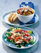 Tuna salad with egg in bowl and herring salad with strawberries on plate