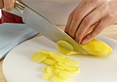 Ginger being cut into slices with knife, step 4