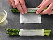 Asparagus being wrapped in tissue paper, step 2