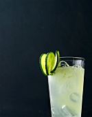 Elderflower and Cucumber fizz with ice and three slices of cucumber on rim