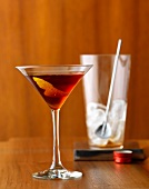 Classic Manhattan in martini glass, mixing glass in background