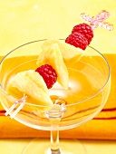 Close-up of cocktail skewer with raspberries on empty glass