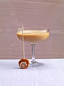 Hot chocolate in cocktail glass with caramel candy stick