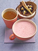 Pink coconut drink in cup and hibiscus tea in glass