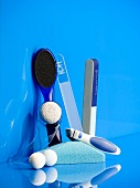 Close-up of cosmetic products for pedicure against blue background