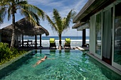 View of swimming pool with palm trees in luxury resort Naladhu, Maldives