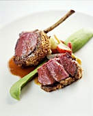 Close-up of rack of lamb with date and mint crust on white background