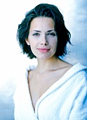 Portrait of beautiful brunette woman in bathrobe, smiling, close-up