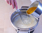 Clarified butter being added to batter for whisking