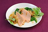 Steamed salmon fillet with ginger and chard leaves on plate