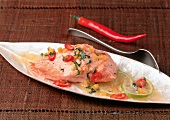 Salmon fillet with chili pepper, mint butter and lime on tray