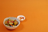 Bowl of potatoes with tuna on yellow background