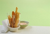 Kohlrabi fries with tomato mayo dip against green background
