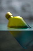 Close-up of green bottle floating in water