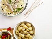 Bowls of potatoes and sausages in marinade