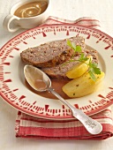 Meatloaf with boiled potatoes and rahmguss on plate