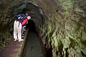 Hikers looking inside tunnel at Levada Tour in Madeira, Portugal