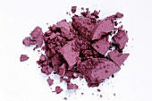 Close-up of loose purple eye shadow on white background