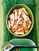 Penne pasta garnished with sweet potatoes and walnuts in pan
