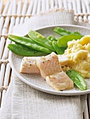 Boneless pangasius fish with mashed potatoes and peas on plate