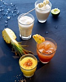 Banana lassi and chai lassi in glasses garnished with banana slices and pineapple