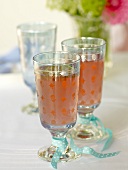 Two rhubarb juice in crystal glasses tied with turquoise ribbon