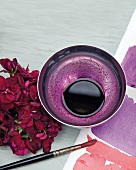 Malen: Geranienblüten rot, Malwasser lila, Papier und Pinsel