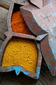 Close-up of red and yellow spices in wooden box