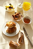Frühstückstisch gedeckt, Croissants, Marmelade, Kaffee, Saft, Obst