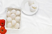 Mozzarella balls with tomatoes on white background