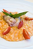 Squid with tomato risotto, cheese and lemon leaves on plate