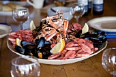 Shrimp, mussels, lobster and lemon wedges on plate