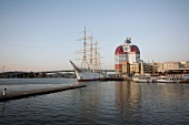 Red and white skyscraper and sailing ship moored at harbour in Gothenburg, Sweden