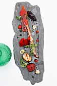 Potpourri of strawberries, Iberian ham and langoustine on white surface, overhead view