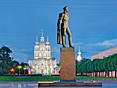 Monument in front of illuminated Smolny Cathedral at night in St. Petersburg, Russia