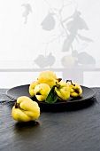 Fresh quinces on black plate