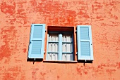 Orange facade of house with blue window shutters, Ticino, Switzerland
