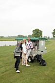 Man and woman standing at food cart on golf court