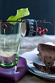 Close-up of berries on branch with wooden ring on glass and pieces of chocolate cake