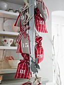 Red and white advent calendar sacks handing on a metal chain