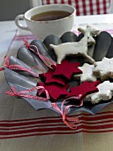 Red felt stars with star shaped cinnamon biscuits and cup of tea on zinc plate